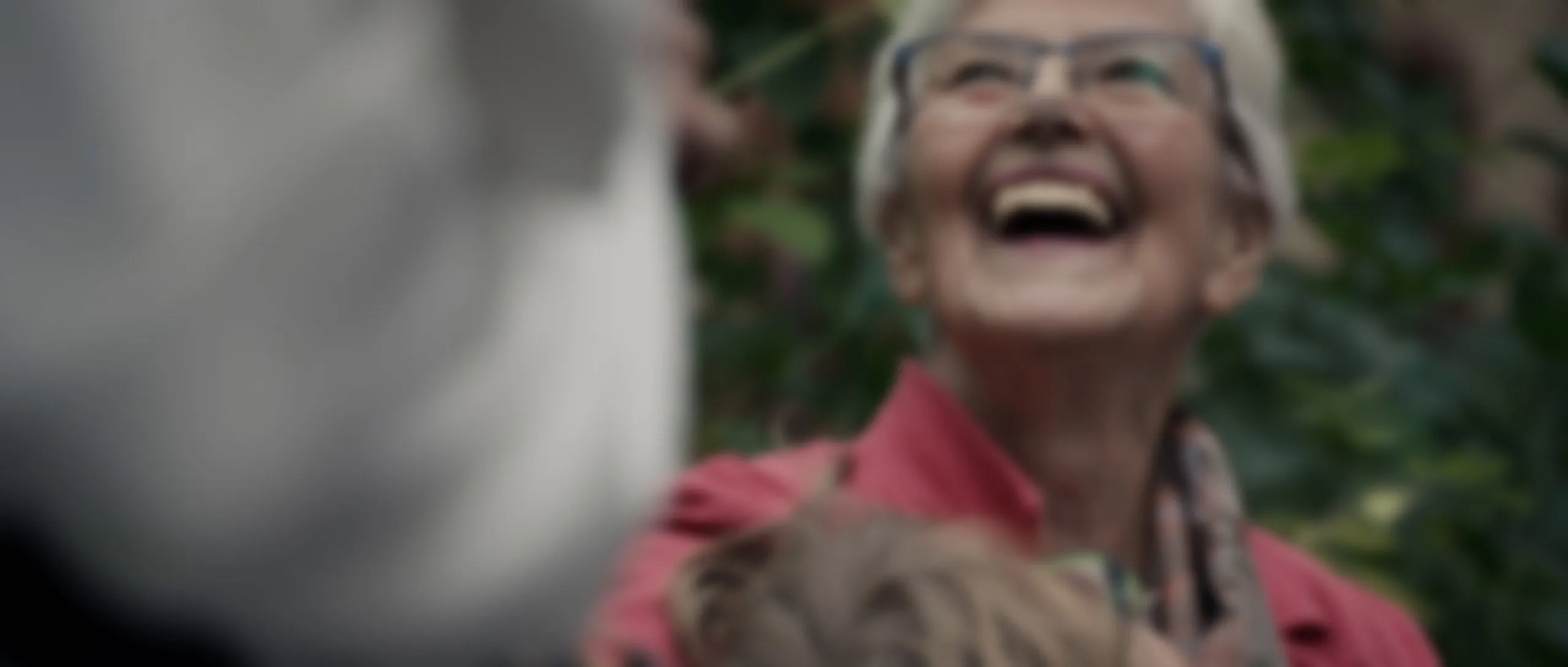 Großmutter hält lachend ihr Enkelkind im Arm (weichgezeichnet)