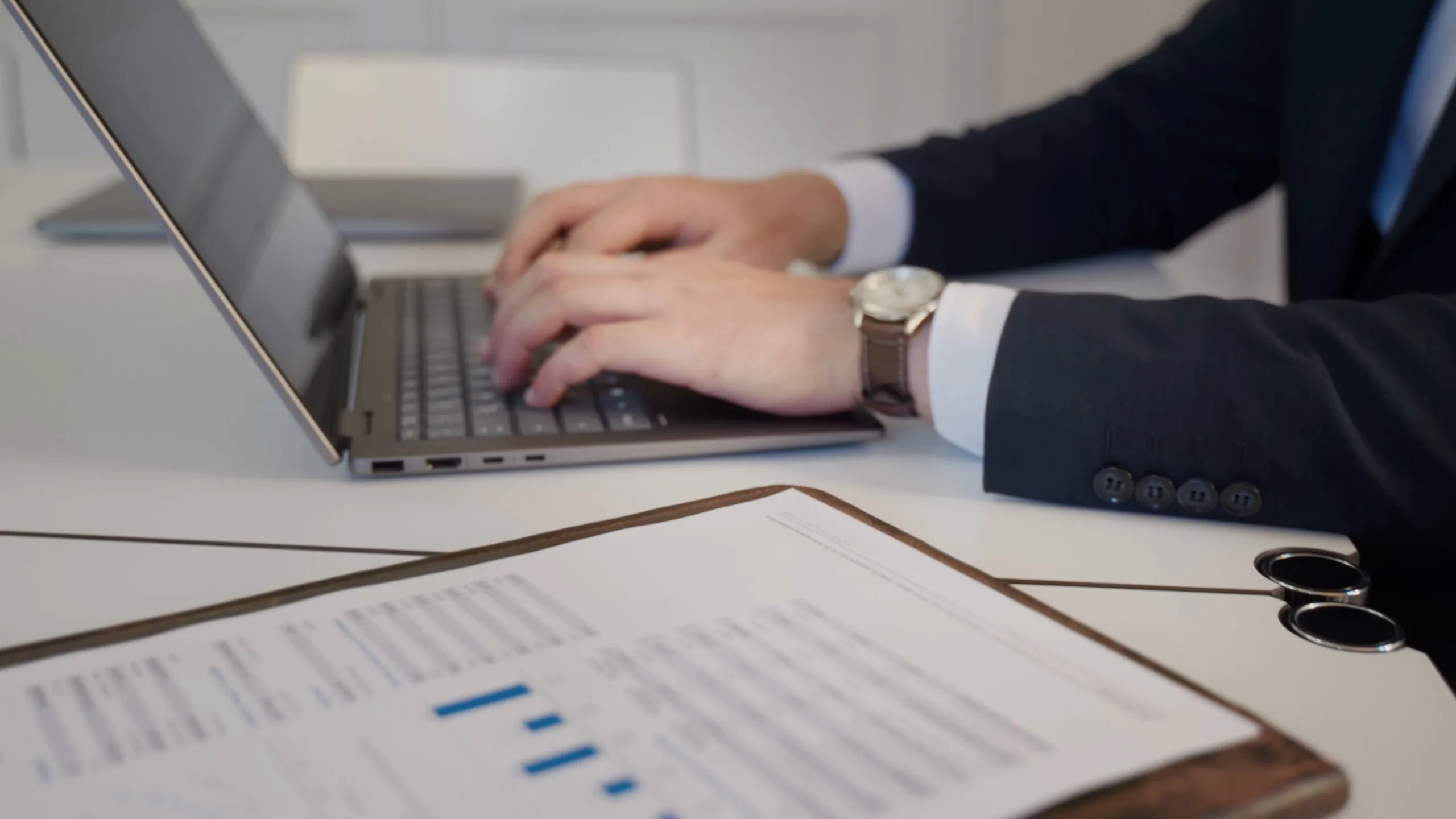 Detailaufnahme: Arbeit am Laptop, davor eine Auswertung